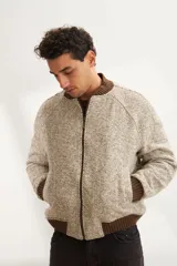 Campera estilo bomber color beige con textura, cierre delantero, cuello, puños y ruedo tejidos. Forrada, confeccionada en lana fina sin teñir.