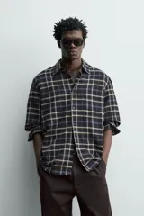 Camisa relaxed fit de franela de algodón, con diseño a cuadros en tonos azul marino, verde y blanco. Cuenta con cuello camisero, manga larga con puños abotonados, bolsillos de parche en el pecho y cierre frontal con botones.