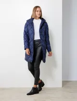 Campera de abrigo color beige con diseño acolchado a rombos, cierre central oculto con botones a presión, bolsillos delanteros con cierre y botones, capucha no desmontable con jareta de ajuste y bolsa autoportante.