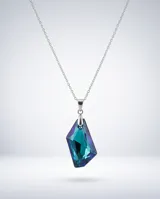 Collar de plata con cadena fina y dije de cristal facetado en forma de gota con tonalidades azul y violeta.