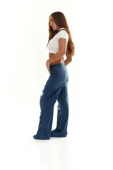 Pantalón de jean azul con corte wide leg y roturas en las rodillas.