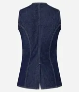 Chaleco de jeans azul oscuro, sin mangas, con cuello redondo y cierre frontal de botones blancos. Presenta un corte ligeramente alargado y solapas frontales que simulan bolsillos.