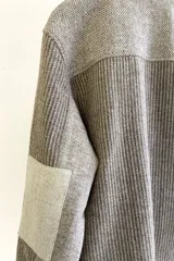 Camisa estilo leñadora con diseño patchwork en tonos marrones y beige. Presenta coderas, cartera americana y bolsillo ojal en el delantero. Confeccionada en Uruguay con tela 100% lana fina sin teñir.