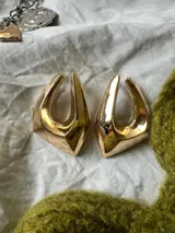 Par de aros dorados con forma geométrica irregular.
