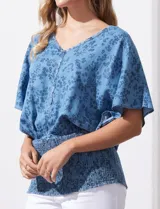 Blusa celeste con estampado floral, escote en V y ruedo smock.