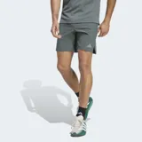 Short deportivo Adidas Designed For Training de color gris, con cintura elástica, cordón ajustable y bolsillos frontales con cierre. Cuenta con el logo de la marca en una de las piernas y aberturas laterales en el dobladillo.
