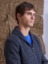 Cardigan de punto con textura en relieve, cuello smoking y cierre frontal completo. Presenta un diseño jaspeado con pequeños puntos de color y bolsillos laterales.