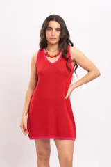 Vestido corto sin mangas, de corte recto y holgado, confeccionado en tejido de punto calado rojo con detalles en tono fucsia en el escote en V, sisas y ruedo.