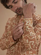 Camisa de manga larga color ladrillo con estampado abstracto en blanco.