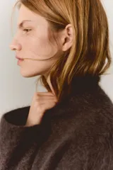 Buzo de corte holgado en punto suave con mezcla de mohair y lana, de color marrón oscuro, con cuello alto, hombros caídos y un bajo superpuesto de encaje en color crudo.