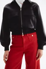 Jean rojo de tiro alto, corte wide leg y diseño tobillero, con bolsillos delanteros tipo parche con botón y pliegues marcados.