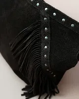 Cartera tipo hobo de gamuza color marrón oscuro, con diseño boho que incluye flecos laterales y detalles de tachas metálicas en el asa y el cuerpo. Cuenta con un compartimento principal amplio y forro interior.
