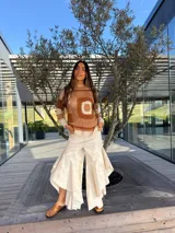 Pantalón de jean azul oscuro con diseño fluido y volados en las piernas.
