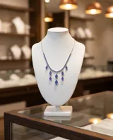 Collar de plata 925 con diseño de cadena fina decorada con pequeñas circonias azules y múltiples dijes colgantes en forma de gota.
