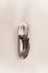 Zapatillas plateadas con detalles en cuero y gamuza color beige. Diseño con puntera perforada, cierre con velcro y suela de goma color caramelo.