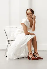 Zapato de tacón ancho color rosa viejo, de tela tipo terciopelo, con puntera fina y tiras cruzadas sobre el empeine.