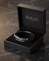 Pulsera de diseño moderno con placa central de acero inoxidable con detalle de ondas grabadas y correa de goma negra.