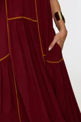 Vestido largo color bordó con escote halter, diseño holgado y detalles de ribetes en contraste.
