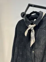 Sobrecamisa negra de pana con cuello camisero y cierre frontal con botones.