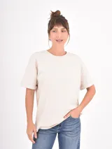 Remera de algodón blanca, de corte holgado y cuello redondo, con mangas cortas de diseño clásico.