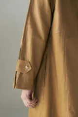 Vestido camisero largo color ocre, con cuello camisero, abotonadura frontal y mangas largas con presillas.