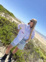 Camisa oversize a rayas verticales azules y blancas, con bolsillo en el pecho con detalle bordado.