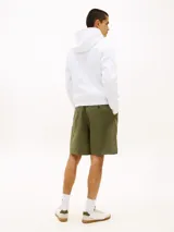 Buzo canguro blanco de puro algodón con capucha ajustable, bolsillo frontal tipo karkur y logo de Tommy Hilfiger estampado en el pecho con detalles en verde.