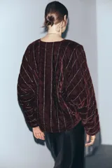Kimono abierto de manga larga confeccionado en tejido de terciopelo acolchado. Presenta un diseño con costuras diagonales decoradas con hilo metalizado y aplicación de abalorios.