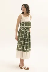 Top de tirantes anchos con diseño bicolor, presentando una parte superior en color crudo y una parte inferior estampada con un patrón geométrico de cuadrícula en negro y blanco.