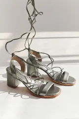 Sandalias de cuero plateado con taco bloque, tiras finas y cordones para atar al tobillo.