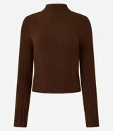 Blusa de punto color blanco con cuello alto y manga larga.