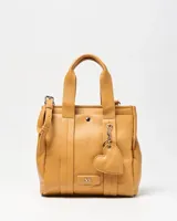 Cartera mediana de símil cuero color habano, con doble asa corta de mano y correa ajustable extraíble. Cuenta con un bolsillo frontal con broche a presión, herrajes metálicos plateados y un llavero colgante en forma de corazón.