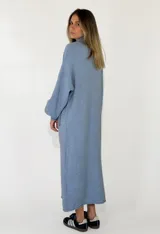 Vestido largo de punto, con cuello alto y mangas largas holgadas. Diseño de corte recto y estilo minimalista.