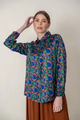 Camisa de poliéster estampada con motivos geométricos en tonos de azul, verde y terracota.