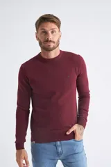 Sweater de tejido de punto en color bordó, con cuello redondo, mangas largas y puños y dobladillo acanalados. Presenta un pequeño logo bordado en el pecho.
