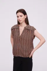 Blusa sin mangas de corte holgado, confeccionada en tela de viscosa con estampado de rayas verticales en tonos mostaza y blanco. Presenta cuello en V profundo y detalles bordados en los hombros.