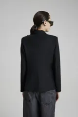 Saco negro de lana con calce entallado, cruzado con botones dorados con pie en delantero y bolsillos sastreros en delantero con tapa.