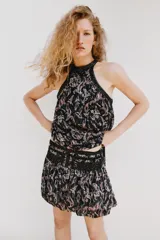 Top halter de tejido estampado con hilo metalizado y lentejuelas, cuello alto y bajo asimétrico con forro interior y cierre trasero con botones.