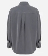Camisa de sastrería oversized color gris, con cuello camisero, cierre frontal con botones y mangas largas con puños anchos.