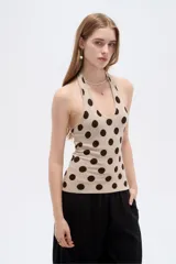 Top de punto al cuerpo con cuello halter, color beige con estampado de lunares marrones.