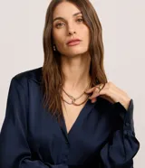 Camisa de satén azul marino, con cuello inglés, manga larga y cierre frontal con botones.