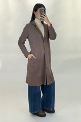 Saco largo de gamuza en color beige, con diseño de solapas clásicas, cierre frontal y corte recto.