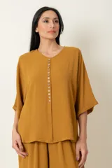 Conjunto de dos piezas compuesto por una blusa de manga corta con cierre frontal de botones y un pantalón ancho de corte holgado con cintura elástica.