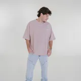 Remera color beige de corte holgado con estampado pequeño en el pecho.