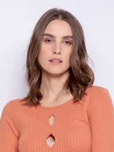 Remera de manga larga confeccionada en tejido acanalado color naranja, con diseño ajustado y aberturas circulares en el escote.