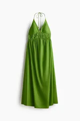 Vestido tobillero de popelina de algodón verde, con escote en V pronunciado, breteles halter finos con cuentas decorativas, cintura fruncida y falda amplia de leve vuelo.