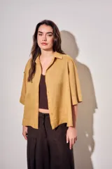 Camisa de lyocell color mostaza, de corte holgado, mangas cortas y cierre frontal con botones.