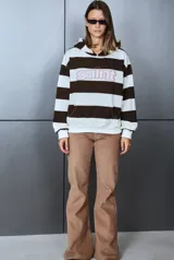 Buzo con capucha estilo canguro, con diseño a rayas horizontales en color negro y blanco. Cuenta con bolsillo tipo canguro al frente y un estampado con letras delineadas en rojo en el pecho.