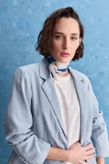 Blazer color beige claro, de corte clásico con solapa, cierre de un botón y bolsillos delanteros de vivo.