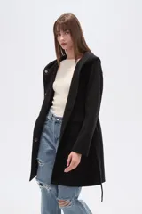 Tapado negro de manga larga con capucha, bolsillos frontales tipo parche y lazo ajustable en la cintura.